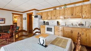 A kitchen with wooden cabinets, a refrigerator, a microwave, and a coffee maker. - Comfy Country Condo (West) on 10 Acres between Bozeman & Big Sky (Gallatin Gateway)