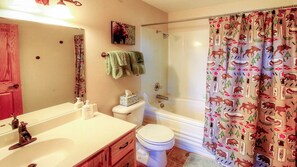 Une salle de bain avec douche, toilettes et lavabo.