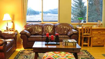 A living room with a brown leather sofa, a wooden coffee table, and a patterned rug.