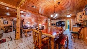 Ein Holzblockhaus-Innenraum mit Essbereich, Küche und Wohnzimmer.