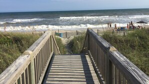 A wooden boardwalk leading to a beach with waves crashing onto the shore. - Spectacular Direct Oceanfront 2BR Condo in Emerald Isle NC Ocean Reef 7B1 (Emerald Isle)