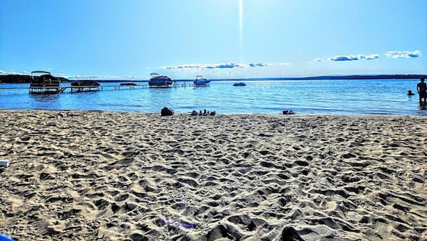Une plage avec des bateaux et un ciel dégagé.
