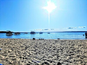 A beach with boats and a clear sky.