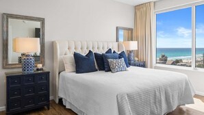 A bedroom with a large bed, two bedside tables, a dresser, and a view of the ocean. - 4 Bedroom/ 3 Bath With Amazing Views, You can Have It All! Modern Condo designed for comfort and Sty (Miramar Beach)