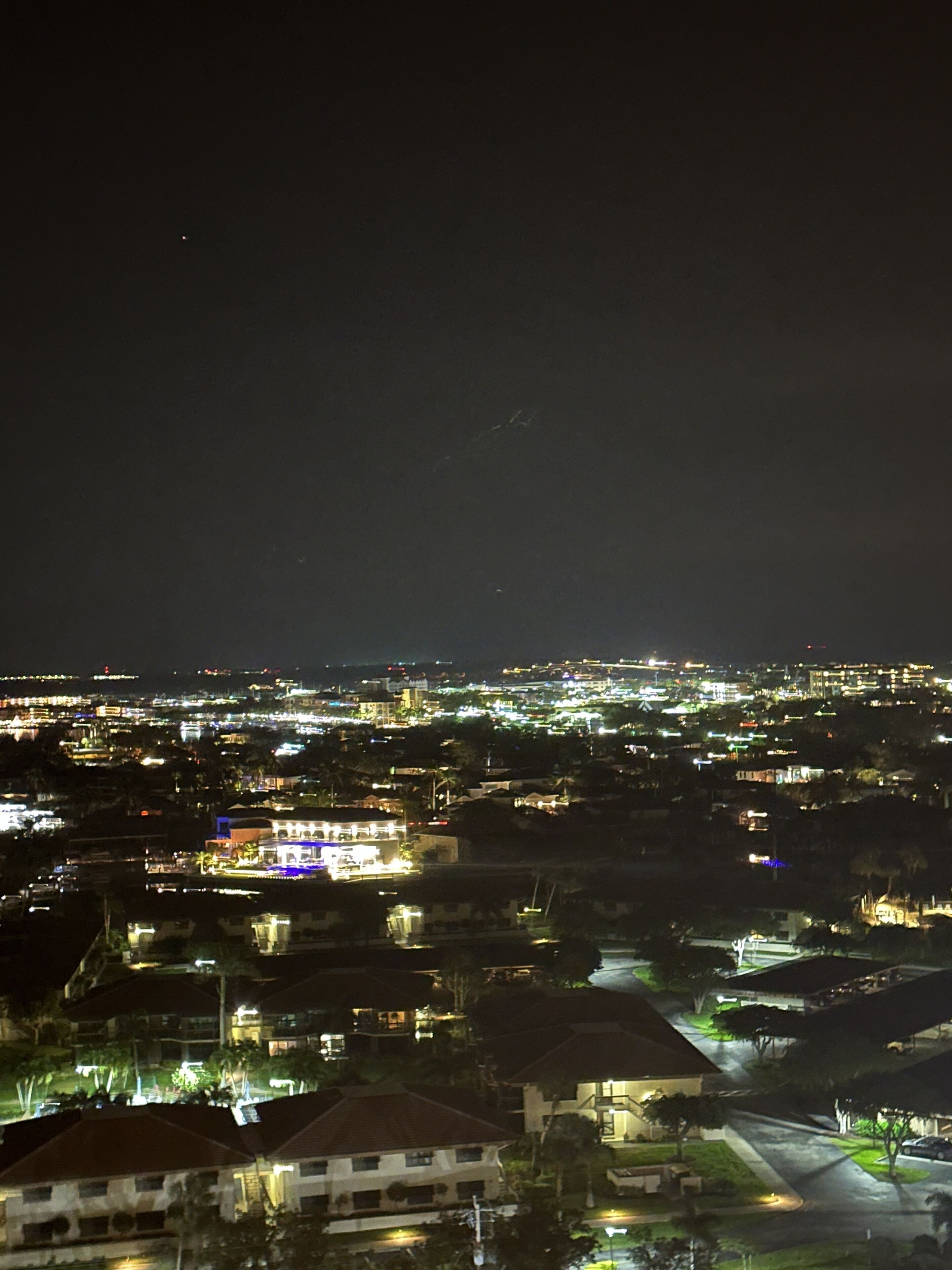 A nighttime cityscape with illuminated buildings and streets.