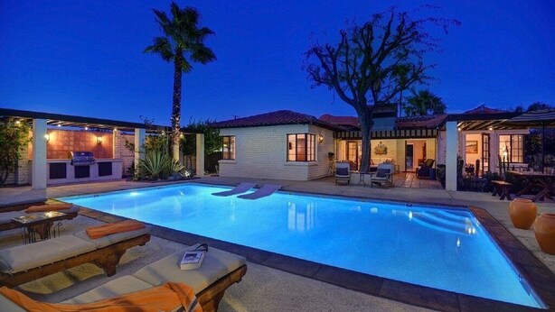 Una piscina con lettini da relax e un'area patio coperta.