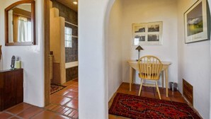 A hallway with a wooden desk, a chair, a rug, and a framed picture on the wall. - Stella Luna in Arroyo Seco - Hot Tub - Longterm (Taos)