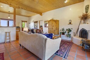 Una sala acogedora con sofá, chimenea y piso de baldosas.