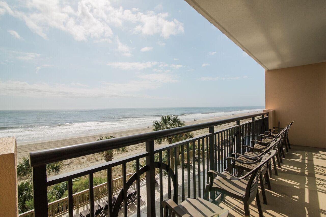 Un balcon avec vue sur la plage et l’océan.
