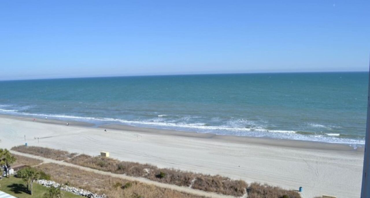 A beach with a clear view of the ocean and a sandy shoreline.