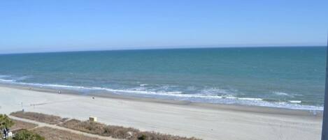 A beach with a clear view of the ocean and a sandy shoreline.