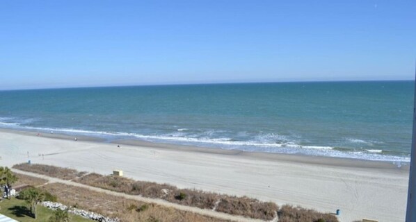 A beach with a clear view of the ocean and a sandy shoreline.