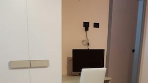 Un dormitorio con una cama, un escritorio y una silla.