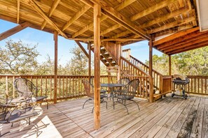 A wooden deck with outdoor furniture and a grill.