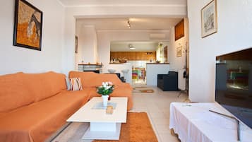 Smart TV, lareira, livros, aparelho de som