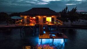 A thatched-roof bungalow with a pool and outdoor seating area, connected by a dock. - All INCLUSIVE BELIZE PRIVATE ISLAND RENTAL WITH OVER WATER BUNGALOW AND CHEF (Belize City)