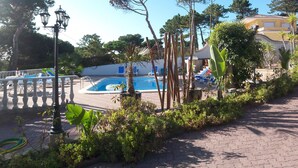 A pool area with lounge chairs and a small inflatable pool.