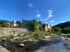 Perched atop a hill, the castle overlooks a serene river meandering through the landscape.