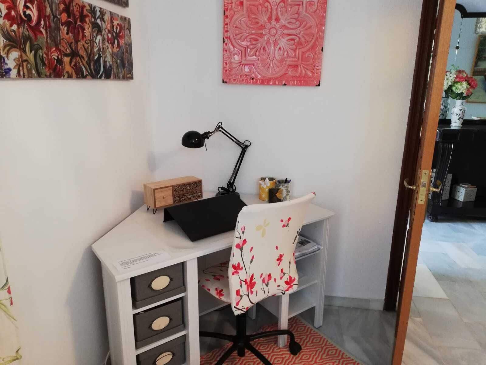 A workspace with a desk, chair, lamp, and storage drawers.