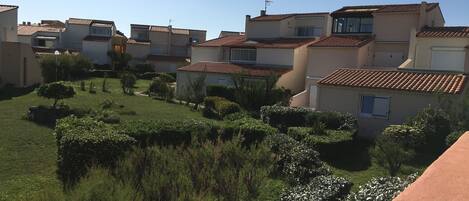 A residential area with multiple houses, each featuring a tiled roof and a small garden area.