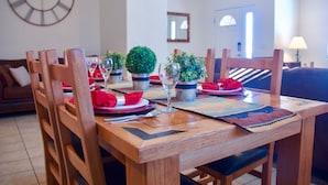 A dining table set with red napkins, plates, and glasses, surrounded by wooden chairs. - Westwater - Spacious 3 Bed, 2.5 Bath Moab House - Sleeps 8 (Moab)