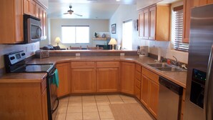 A kitchen with wooden cabinets, a microwave, a refrigerator, and a dishwasher. - Westwater - Spacious 3 Bed, 2.5 Bath Moab House - Sleeps 8 (Moab)