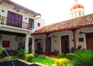 A courtyard with a pool, a covered patio, and a building with a dome. - Casa Blanca, Beautiful Restored 250 Year Old Villa. Oasis in Heart of Granada (Granada)