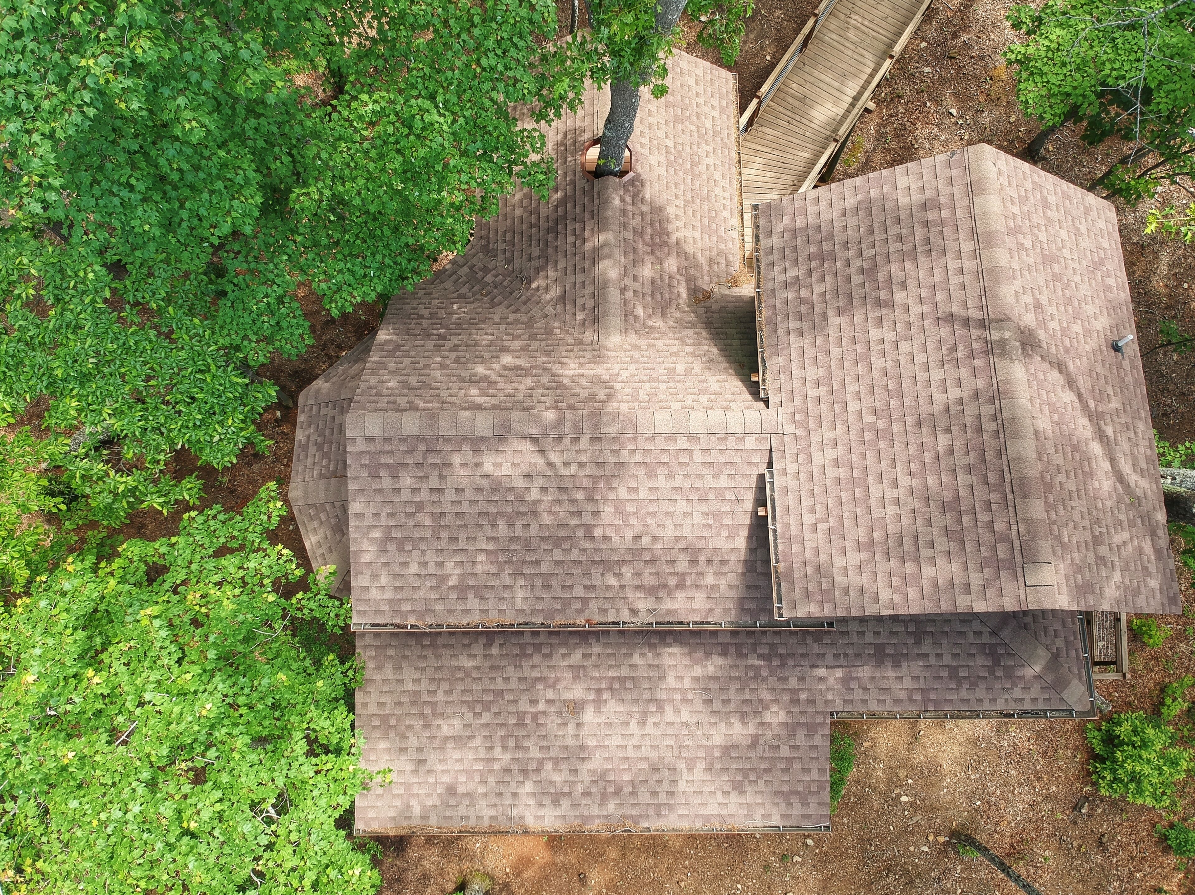 A house with a sloped roof and a brick chimney.