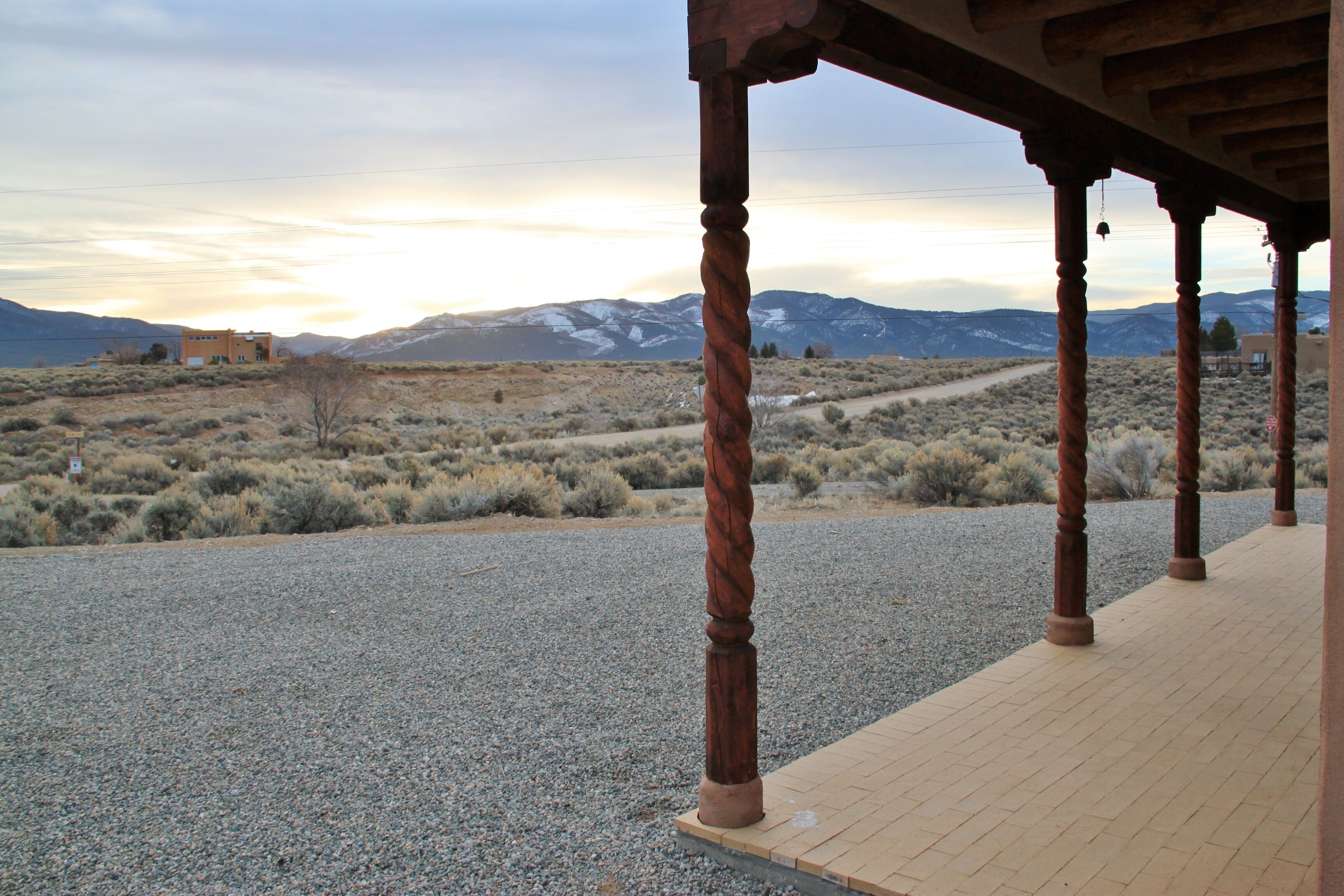 A covered outdoor area with a gravel path leading to a building.