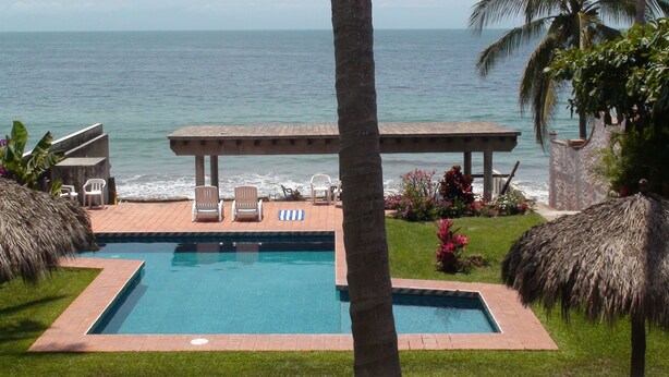 A swimming pool with lounge chairs and a view of the ocean. - BEACHFRONT on a Budget! ~ Condo Sereno ~ Low Beachfront Rate! (BUCERIAS)