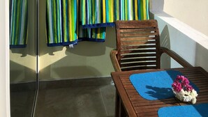 A balcony with striped towels, a star decoration, a blue lizard ornament, and a wooden chair with a blue mat and flowers. - BEACHFRONT on a Budget! ~ Condo Sereno ~ Low Beachfront Rate! (BUCERIAS)