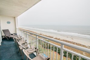 A balcony with beach views, featuring lounge chairs and a small table. - Direct Oceanfront 3BR/2BA, Park on same level as condo (Myrtle Beach)