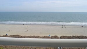 A beach with people walking and playing, and a calm sea. - Direct Oceanfront 3BR/2BA, Park on same level as condo (Myrtle Beach)