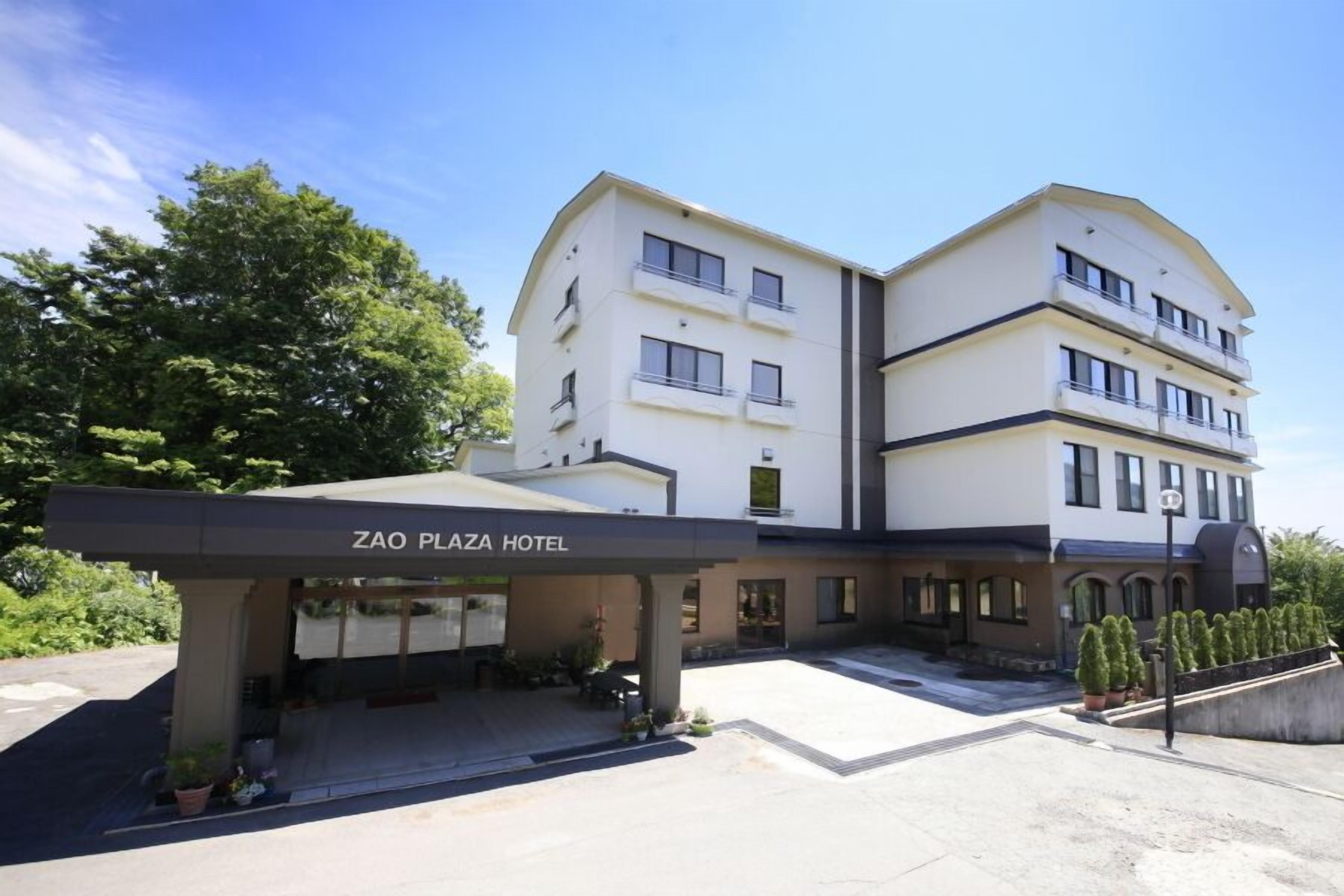 A two-story hotel with a covered entrance and a sign reading "Zao Plaza Hotel".