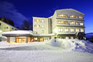 Vista frontal de la propiedad por la tarde o noche