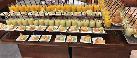 Um buffet com diversos alimentos e bebidas.