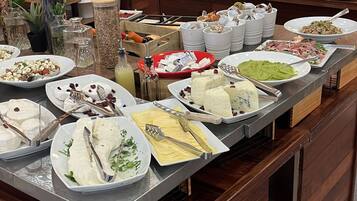 A buffet setup with various food items and utensils.