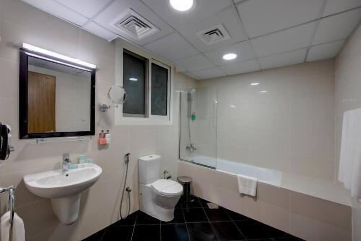 A bathroom with a sink, toilet, and shower area.
