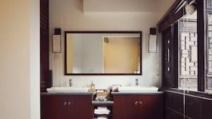 Un baño con dos lavamanos, un espejo grande y armarios de madera oscura.