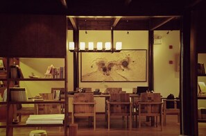 Une bibliothèque accueillante, dotée de meubles en bois, d’un grand tableau abstrait et d’une atmosphère chaleureuse.