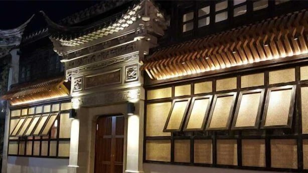 Un edificio tradicional con techo de tejas y puerta de madera.