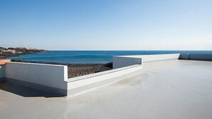 A rooftop terrace with a clear view of the sea and a distant coastline. - Pension Jung Won (Seogwipo)