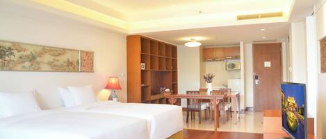 A hotel room with a bed, a desk, and a television.