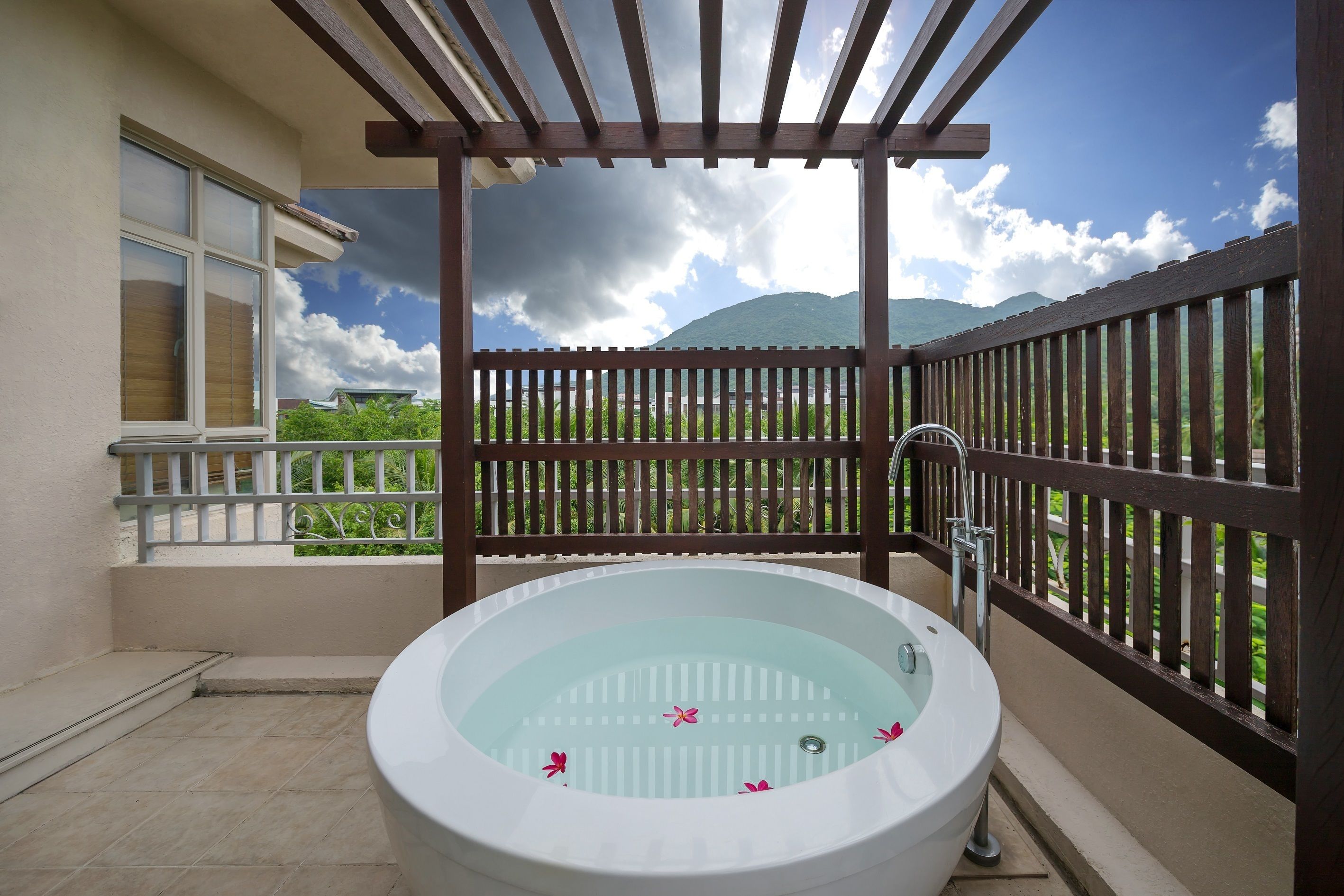Un balcon doté d’un jacuzzi, d’une pergola et offrant une vue sur les montagnes.