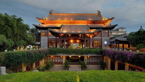 Een traditioneel Chinees gebouw met een symmetrisch dak en een centrale ingang.