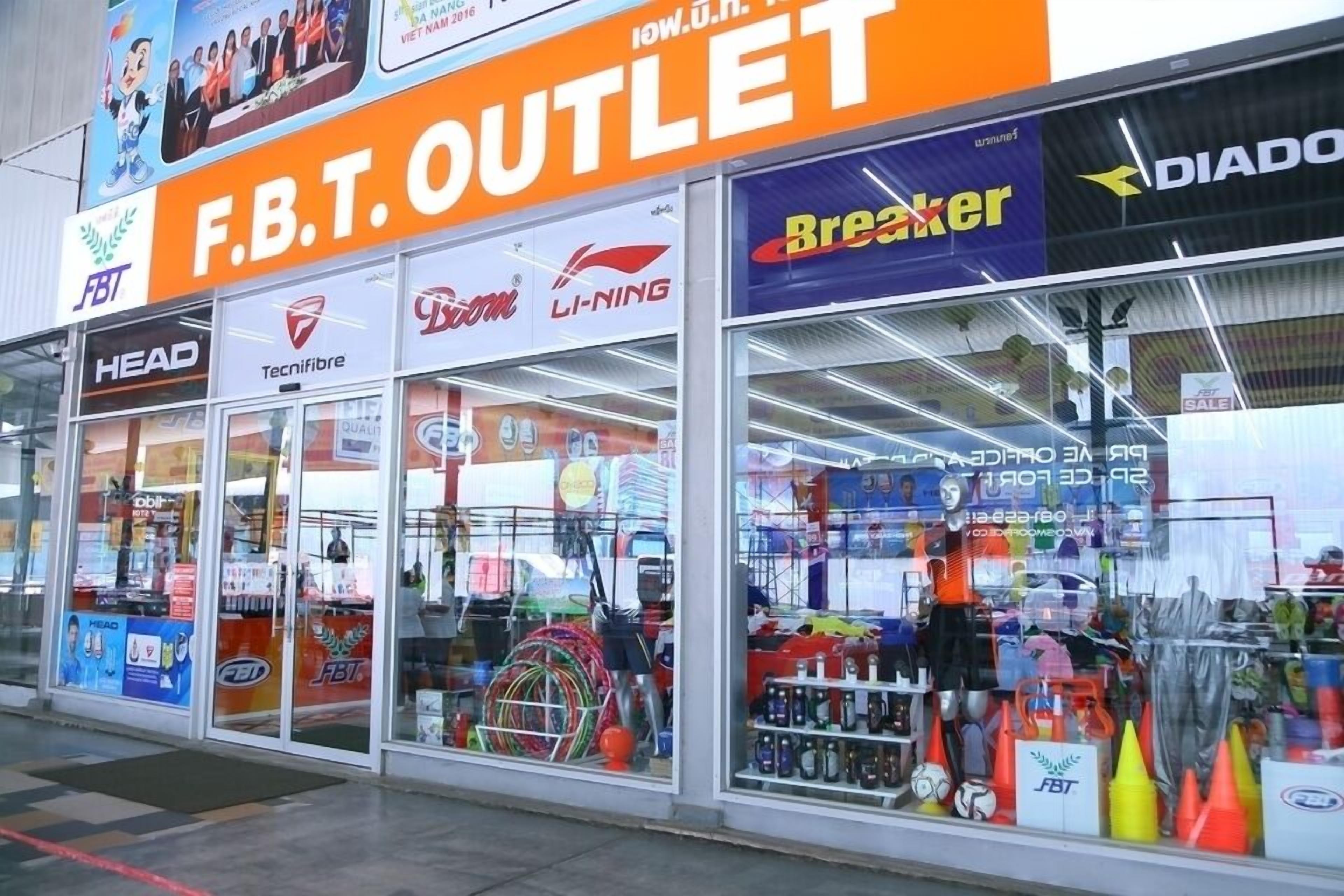 A storefront with the sign "F.B.T. OUTLET" and various sports equipment visible through the glass.