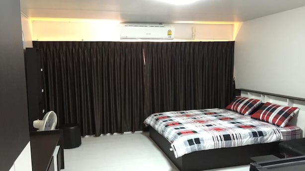 Een moderne slaapkamer met een bed, een bureau en een airconditioning.