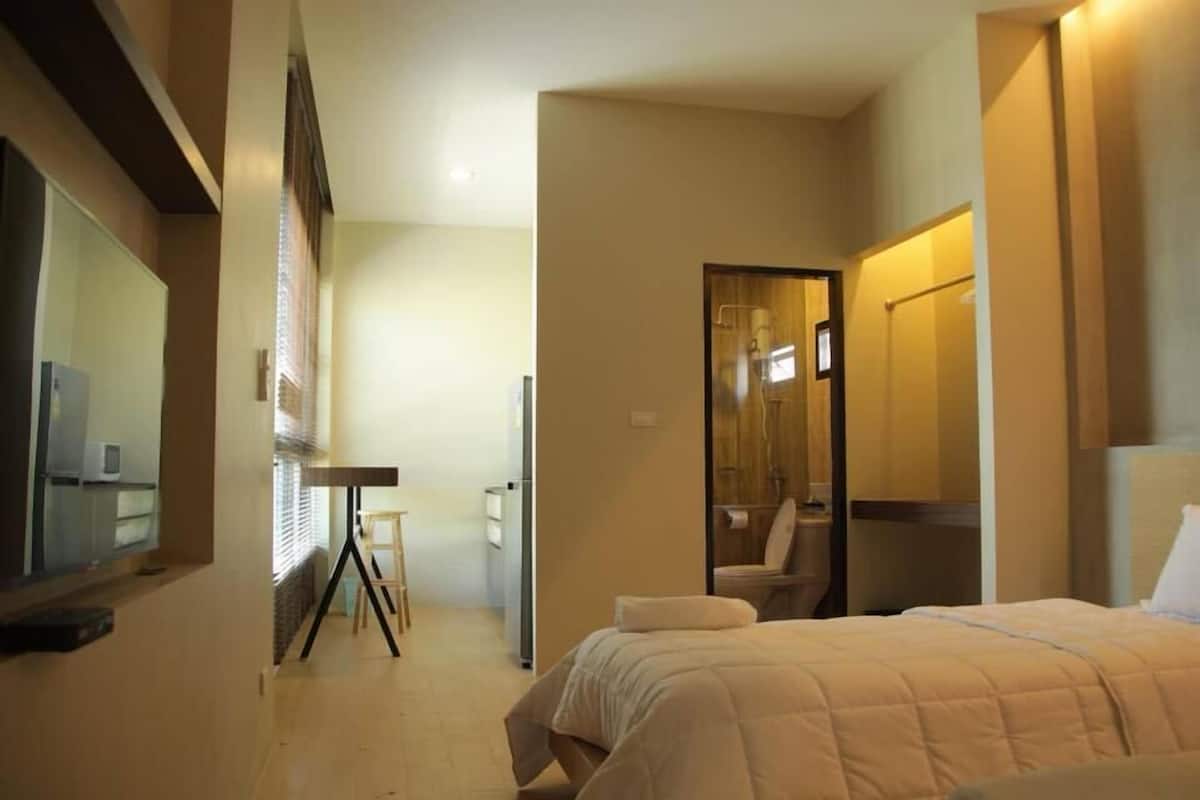 A hotel room with a bed, a desk, and a bathroom.