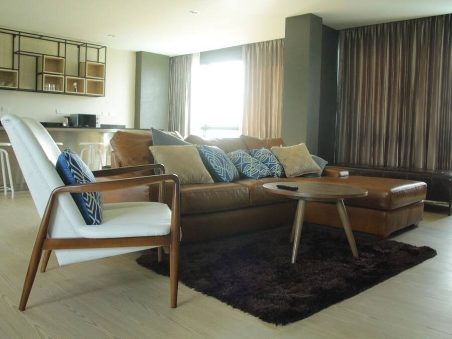 Una sala de estar moderna con un sofá, un sillón y una mesa de centro.