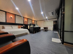 A hotel room with a bed, a desk, a chair, and a small table. - GoldenRoot Hotel in Gimhae (Gimhae)